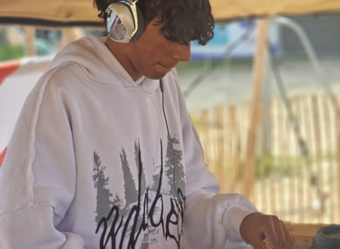 a man in a white hoodie and headphones on a dj - zil