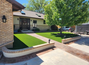 artificial turf in the front yard landscaping wrapped around a tree and on either side of a walkway