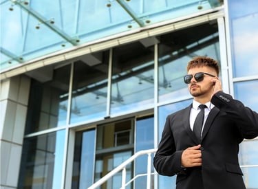 Force Prévention Sécurité – Agent de sécurité en costume noir, équipé d'oreillettes et de lunettes de soleil, assurant la sur