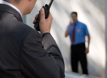 Force Prévention Sécurité – Agent de sécurité en costume noir, équipé d'oreillettes et de lunettes de soleil, assurant la sur