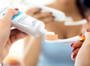 a woman is holding a toothbrush and toothbrush in her hand