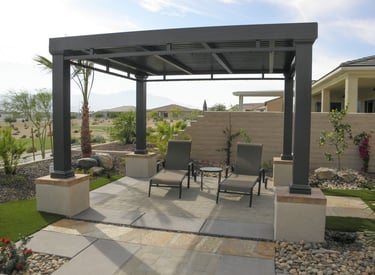 A patio cover with two chairs underneath