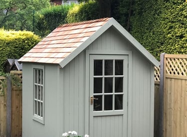 A small shed with a window and a yard.
