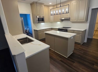 Modern kitchen remodel featuring beige cabinets, white quartz countertops, and a kitchen island.