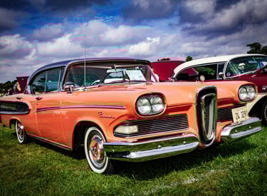 a vintage car parked in a grassy field