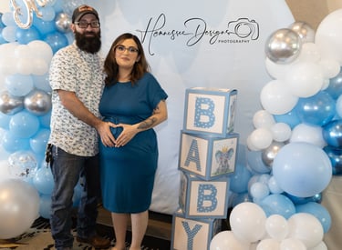 a man and woman standing in front of a baby shower