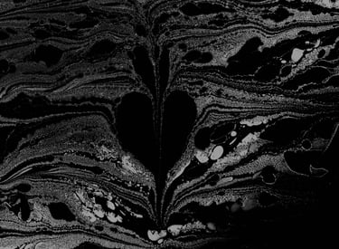 A bleeding heart found emerging from formed and swirling ink on water