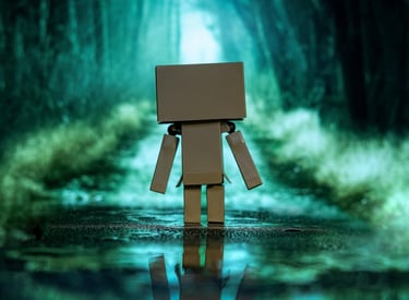 blurry scene of a blue and green forest with a walkingtoy robot in focus in the center from the back