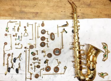 un saxophone soprano entièrement démonté avec ses clefs disposées à côté