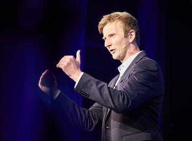 a man in a suit and tie is giving a speech