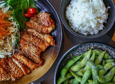 Grilled sesame chicken teriyaki served with fresh garden salad, white rice, and salted edamame.