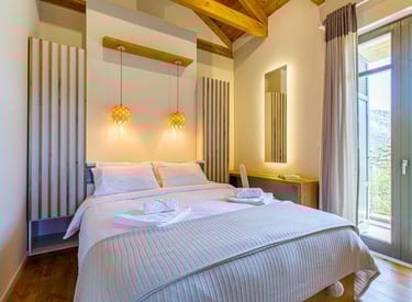 Bright bedroom with double bed and mountain view balcony at Villa Skyphos, Crete