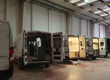 Interior del taller de innovans donde aparecen distintas furgonetas en proceso de camperizacion