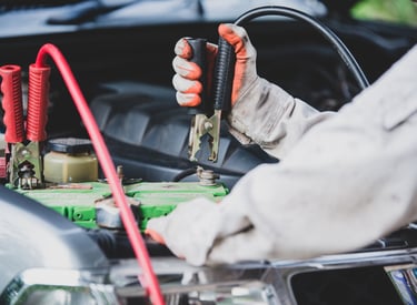 a man in a white shirt is holding a jump cable