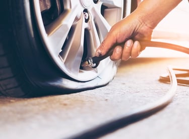 a person is checking tire pressure of a car
