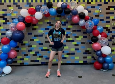 a woman standing in front of a balloon - shaped balloon