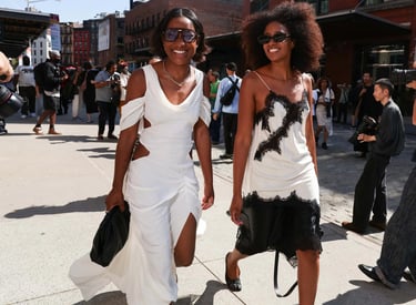 Street style at NYFW SS26: guests in chic white and black dresses with cut-out and lace details.