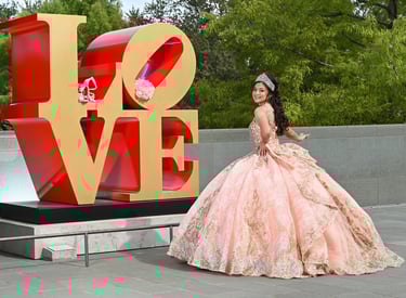 a woman in a pink dress standing in front of a love sign