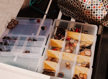 Des bijoux brodés rangés dans une boite à compartiments