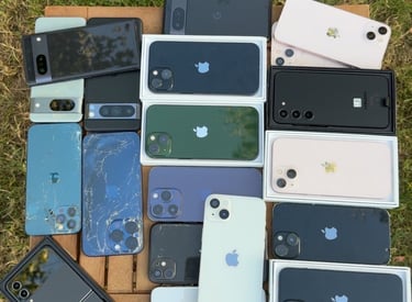 a bunch of different colored phones on a table in a garden