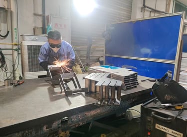 Professional welder in safety gear welding custom metal components