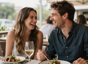 A couple sitting by a campfire near a serene lake at sunset.