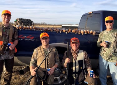 A group of four hunters celebrating a successful day of bird hunting in the Texas Panhandle.