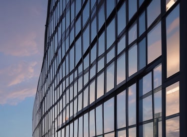 Close-up of modern glass facade reflecting sunlight on a corporate building.