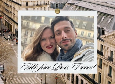 A smiling couple takes a selfie in a Polaroid-style frame with a Paris, France cityscape backdrop.