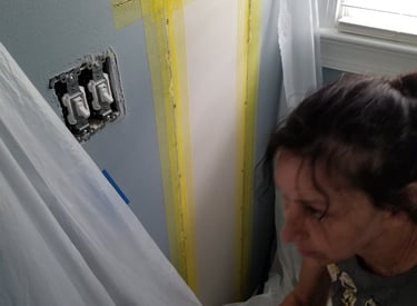 A picture of Janet Graybill doing a wall repair.