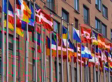 A series of custom printed flags fluttering in the wind outside a storefront.