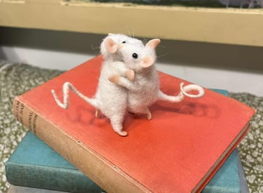 a mouse mouse sitting on top of a pile of books