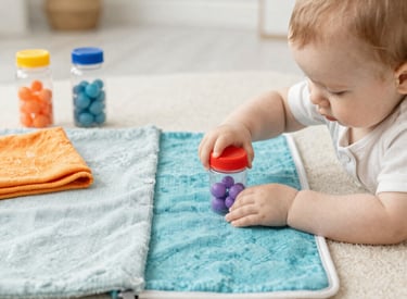 Close-up of handcrafted wooden rattles made in France, resting on a soft blanket.