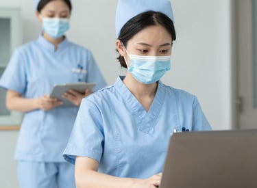 Close-up of hands organizing credentialing paperwork with a stethoscope on the desk.