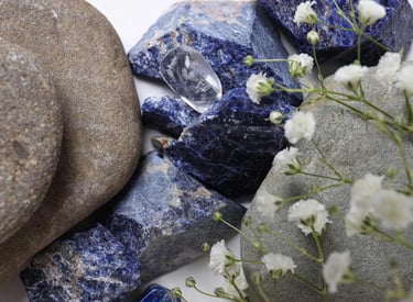 Piedras preciosas azules junto a piedras de rio y flores blancas