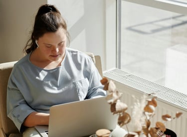 a woman sitting in a chair with a laptop computer