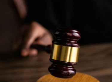 a judge's gavel with a gavel on a wooden table
