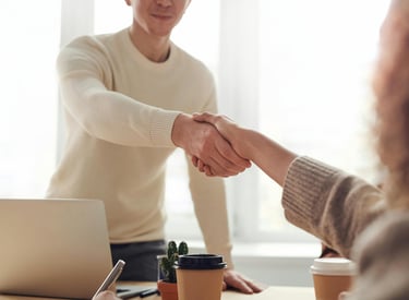 a man and woman shaking hands in a meeting