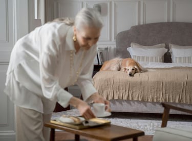 a woman in a white shirt and a dog on a bed