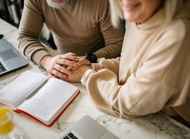 a man and woman holding hands over a notebook