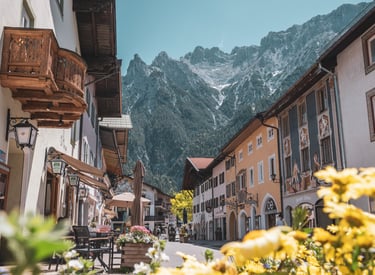 Traditional Bavarian village street in Mittenwald with colorful houses and the Karwendel mountains.