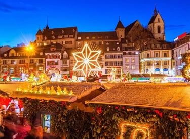 A festive European Christmas market at night with glowing star decorations and snowy stalls.