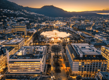 Aerial view of Bergen city center at twilight featuring the Lille Lungegårdsvannet lake and Christmas market.