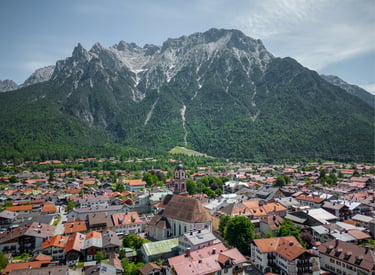 Aerial view of Mittenwald village with red roof houses and the Karwendel mountains in the Bavarian Alps.