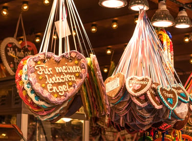 Traditional decorated German gingerbread heart cookies hanging at a festive Christmas market stall.