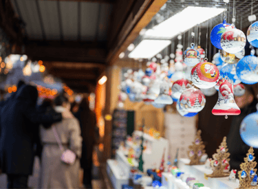 Colorful hand-painted glass ornaments hanging at a European Christmas market stall.