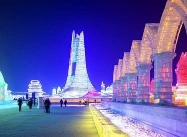 Illuminated ice sculptures and towers at the Harbin International Ice and Snow Festival at night.