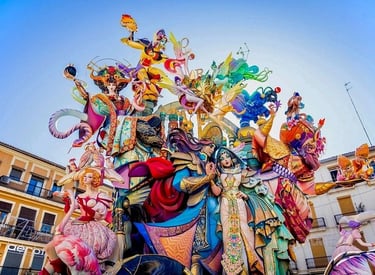 A colorful Las Fallas monument featuring ornate, towering sculptures during the festival in Valencia, Spain.