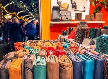 Handmade leather wallets and purses displayed at a festive outdoor Christmas market stall.
