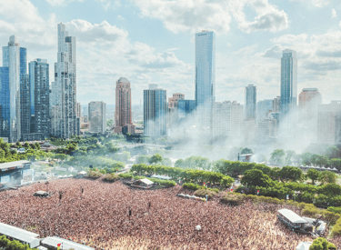Aerial view of a crowded music festival in Grant Park with the Chicago skyline in the background.